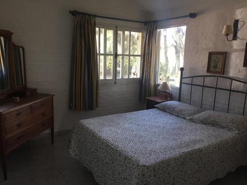 马尔多纳多Casa Azul的一间卧室配有一张床、一个梳妆台和一扇窗户。