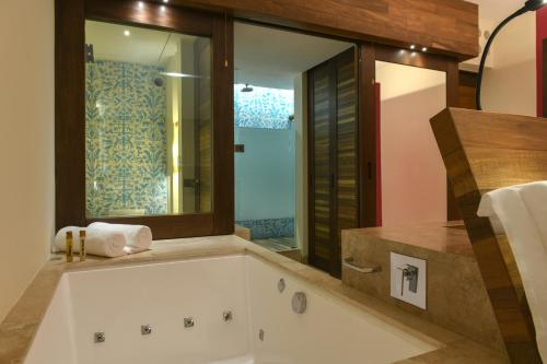 普拉亚卡门Hotel Xcaret Mexico All Parks All Fun Inclusive的带浴缸和窗户的浴室