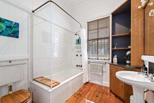 土乌巴Frangipani House的白色的浴室设有浴缸和水槽。