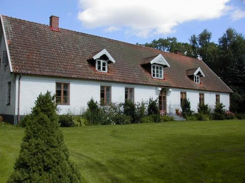 埃斯勒夫Bo i Remmarlöv的白色的房子,有红色的屋顶和院子