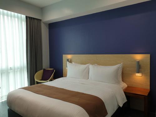 马尼拉Leez Inn Makati的一间卧室设有一张蓝色墙壁的大床