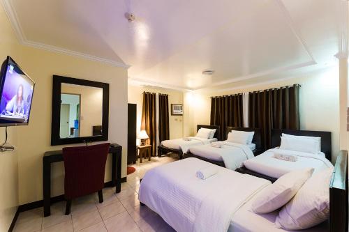 巴斯科Batanes Seaside Lodge & Restaurant的一间酒店客房,设有三张床和一台平面电视