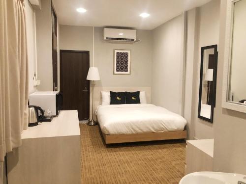 曼谷GN豪华旅舍的一间卧室,床上有一只黑猫