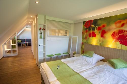 温德尔斯巴赫盖斯特豪弗林顿和威尔德克奥特酒店的卧室配有一张床,墙上挂有绘画作品