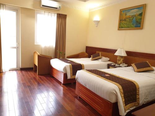胡志明市Huong Sen Hotel的酒店客房设有两张床和窗户。