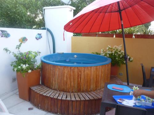 卡塔赫纳扎纳精品酒店的甲板上的热水浴池,配有红色遮阳伞