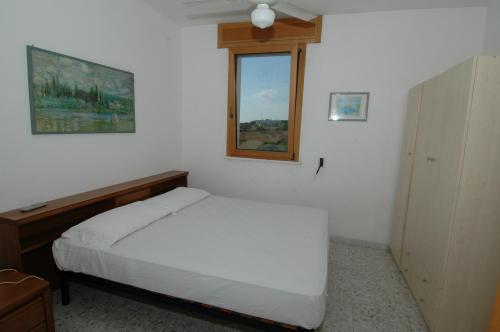 莱乌卡Residence Trande的卧室配有白色的床和窗户。