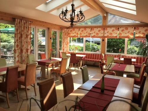 登肯多夫Gasthof Lindenwirt的餐厅设有桌椅和窗户。