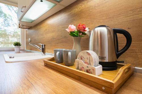 瓦尔纳Apartment DOLCE CASA的厨房柜台设有带茶壶和杯子的托盘