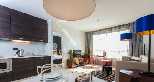 巴塞罗那巴塞罗那辉盛凯贝丽酒店式服务公寓的厨房以及带桌子的客厅。