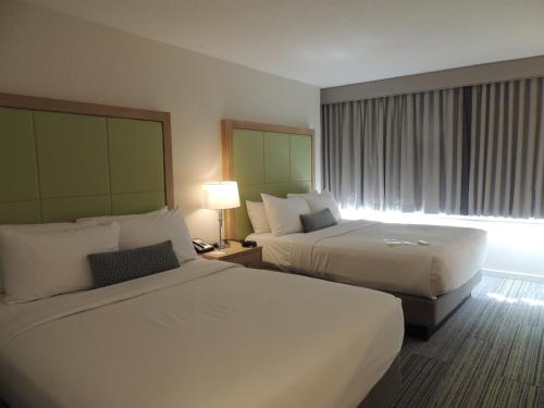 波士顿朗伍德疗养酒店的酒店客房设有两张床和窗户。