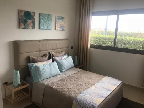 西迪拉哈尔Appartement Blanca Beach的卧室配有带枕头的床铺和窗户。