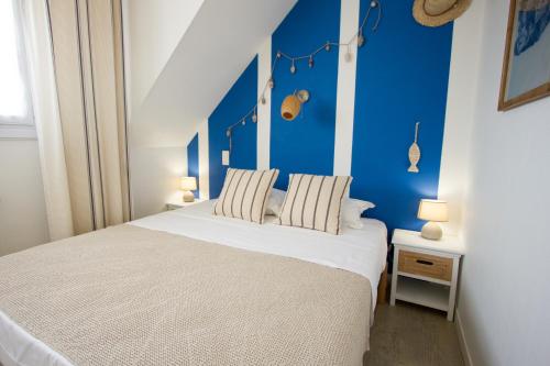 勒宝利古恩Casa Cosy Le Pouliguen的卧室配有白色床和蓝色墙壁