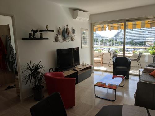 卢贝新城French Riviera Condo 4 Rent in Marina Baie des Anges的客厅配有平面电视和椅子