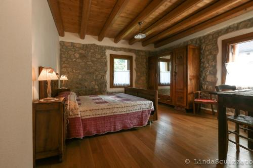 LastebasseIl Capriolo Felice - Agriturismo的铺有木地板的客房内设有一间卧室和一张床。