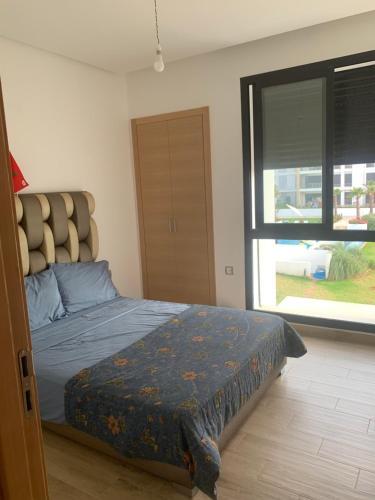 西迪布克纳德尔Presigia plage des nation Vacation Home的一间卧室设有一张床和一个大窗户