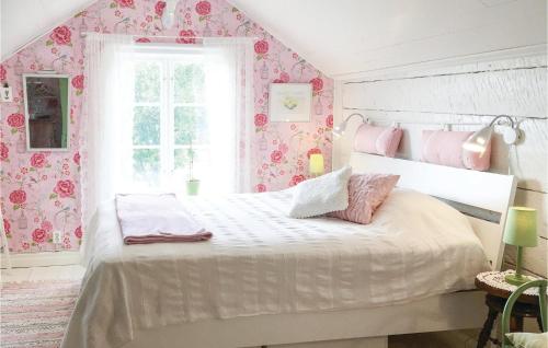 SollebrunnLovely Home In Sollebrunn With Wifi的卧室配有白色床和粉红色花卉壁纸