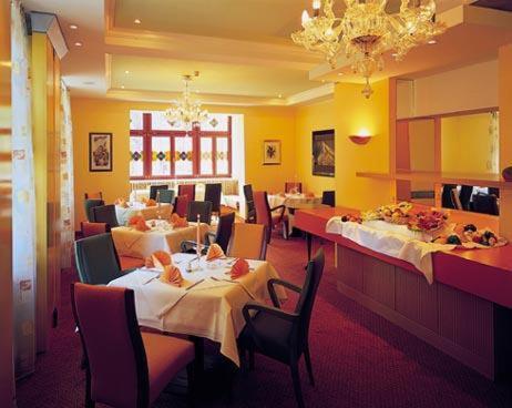 舍纳贝克浴疗公园酒店的一间带桌椅的餐厅和一间用餐室