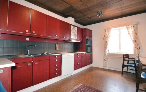 ÄlvstorpStunning Home In Tidaholm With 5 Bedrooms, Sauna And Wifi的一个带红色橱柜和窗户的大厨房