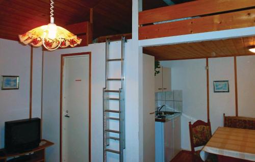 瓦尔内明德Beautiful Home In Hohe Dne With Kitchen的一间设有梯子的客房,通往一个配有电视的房间