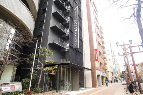 广岛Hotel Kuretakeso Hiroshima Otemachi的建筑的侧面有标志