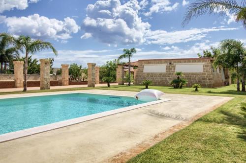 科尔萨诺Tenuta De Masi的棕榈树屋前的游泳池