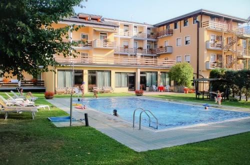 莱维科特尔梅Hotel Dolomiti的一座游泳池,人们在大楼前玩