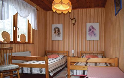 AnkarsrumCozy Home In Ankarsrum With Lake View的一间卧室配有两张单人床和吊灯。
