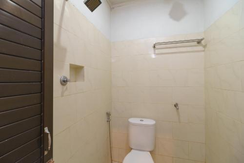 班达亚齐RedDoorz Syariah @ Panglima Nyak Makam Aceh的浴室配有白色卫生间和淋浴。