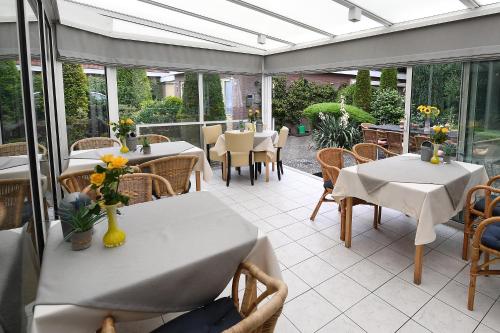 费尔普Motel Koolen的一个带桌椅的温室和一个带桌子及桌面的庭院