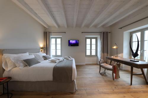 奥利维托拉里奥Villa Mojana Bellagio的卧室配有一张床、一张书桌和窗户。