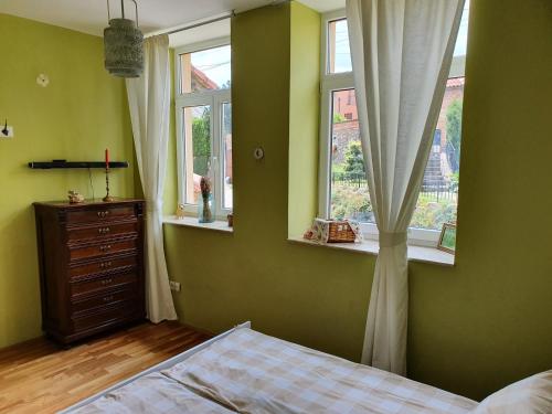 佩奇Virág Wellness Villa的一间卧室设有绿色的墙壁、窗户和一张床