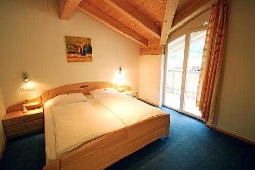 纳图尔诺Garni Sonnblick的一间卧室设有一张床和一个大窗户