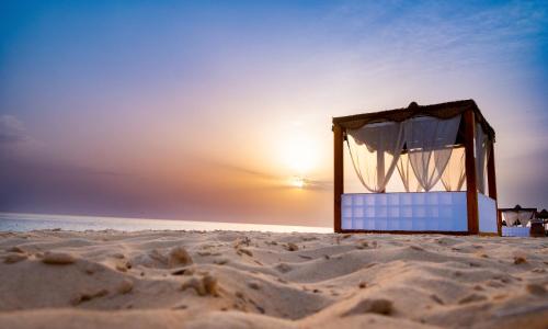 马特鲁港凯撒湾度假酒店的沙滩上的一张床位