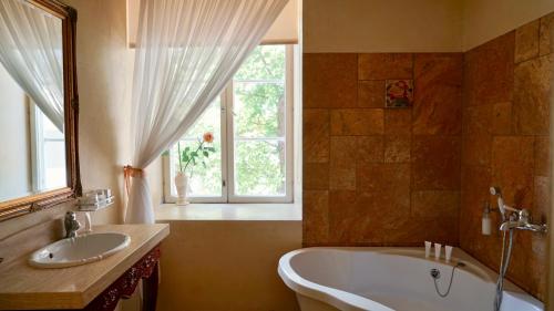 库雷萨雷格兰德玫瑰SPA酒店的带浴缸、水槽和窗户的浴室