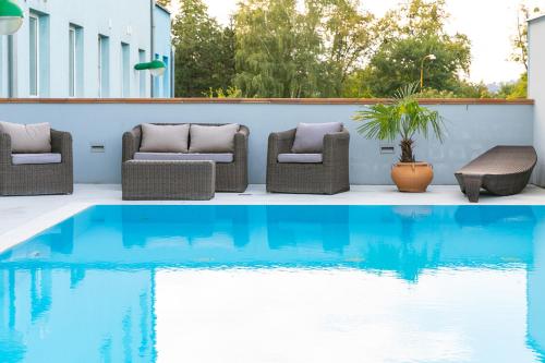 瓦拉什斯凯梅济日奇埃伯基康体酒店的一个带两把椅子的庭院和一个游泳池