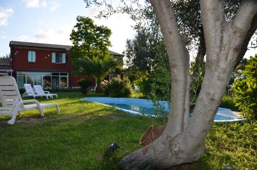 锡罗洛Borgo Rosso Country House B&B的一个带游泳池和房子的庭院