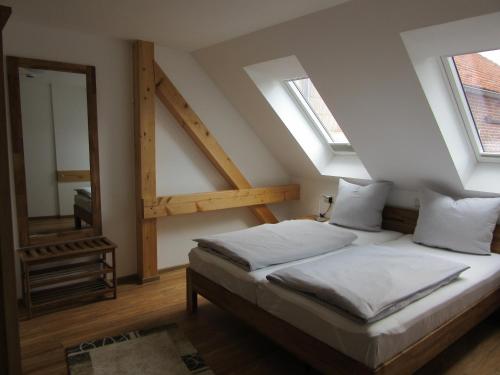 BürgelFeriendomizil Taupadel的一间卧室设有一张床和两个窗户。
