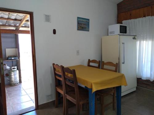 圣罗莎卡拉穆奇塔县Departamento Loma Hermosa的厨房配有桌椅和冰箱。