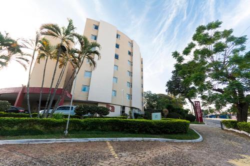 坎皮纳斯坎皮纳斯里加别墅酒店的街道前方有棕榈树的建筑