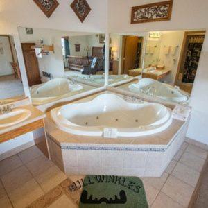 波普勒布拉夫Bullwinkles Rustic Lodge的大型浴室设有两个盥洗盆和一个大浴缸。