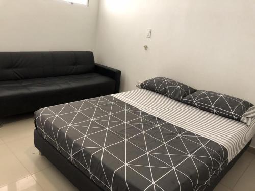 圣玛尔塔EDIFICIO PALANOA APTO 507PQ RODADERO的一间卧室配有一张床和一张沙发