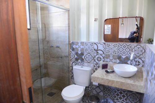 新彼得罗波利斯Pousada Charme e Estilo的浴室配有卫生间、盥洗盆和淋浴。