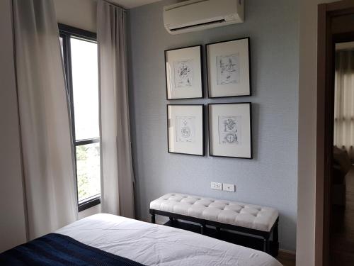 七岩Rain Cha-am Huahin by Smiley的卧室配有一张床,墙上挂着框图