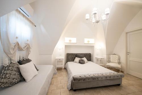 佩兹迪格雷科Il Vecchio Frantoio的白色卧室配有床和沙发