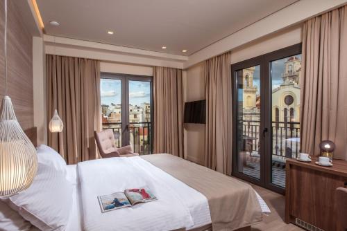 海若克利欧Metropole Urban Hotel的酒店客房设有一张床和一个阳台。