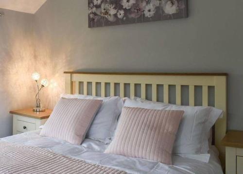 阿什福德Hollyhock Cottage的一间卧室配有一张带两个粉红色枕头的床