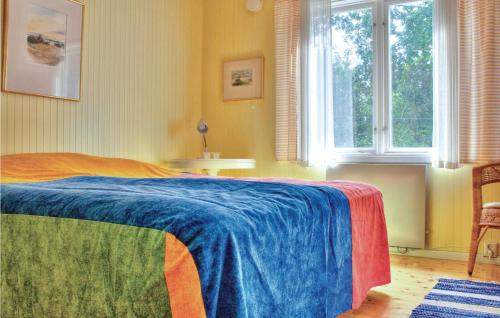 费尔耶斯塔登Gorgeous Home In Frjestaden With Wifi的一间卧室配有一张带蓝色毯子的床