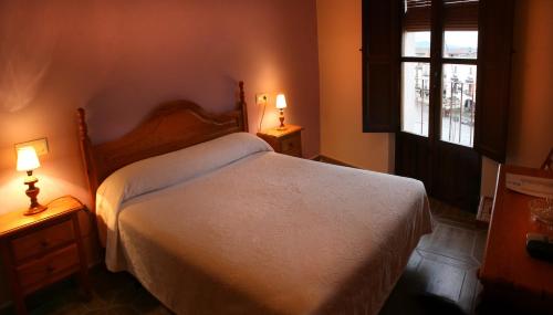 特鲁希略马约尔广场旅馆的卧室配有白色的床和两盏灯。