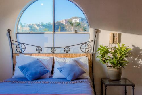 卡波圣卢卡斯Los Milagros Hotel的一间卧室设有一张大床和大窗户